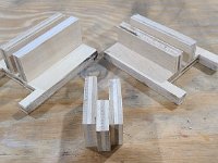 2022-03-21 14.02.53  Suggested tool: Make some jigs to align the Front Guides and to accurately nail them to the column guides.  The back two jigs center and height-adjust the Front Column Guides.  The jig in the foreground slides aliong the right edge of the Front Column Guide and shows where to pop a brad nail in the dead center of a (slightly warped) column guide.